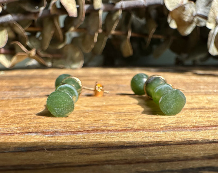 Close up of Jade Bamboo Earrings featuring round jade tops and tapered bamboo drops with gold caps