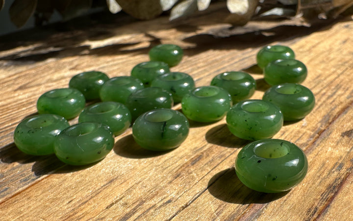 Close up of green donut beads arranged on a sunlit wooden surface