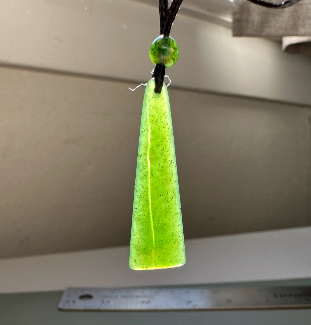 Canadian jade drop pendant in neon lime on a black cord with a small round bead above