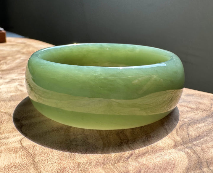 A Grade Siberian Bangle green jade with a lighter central band and glossy finish.