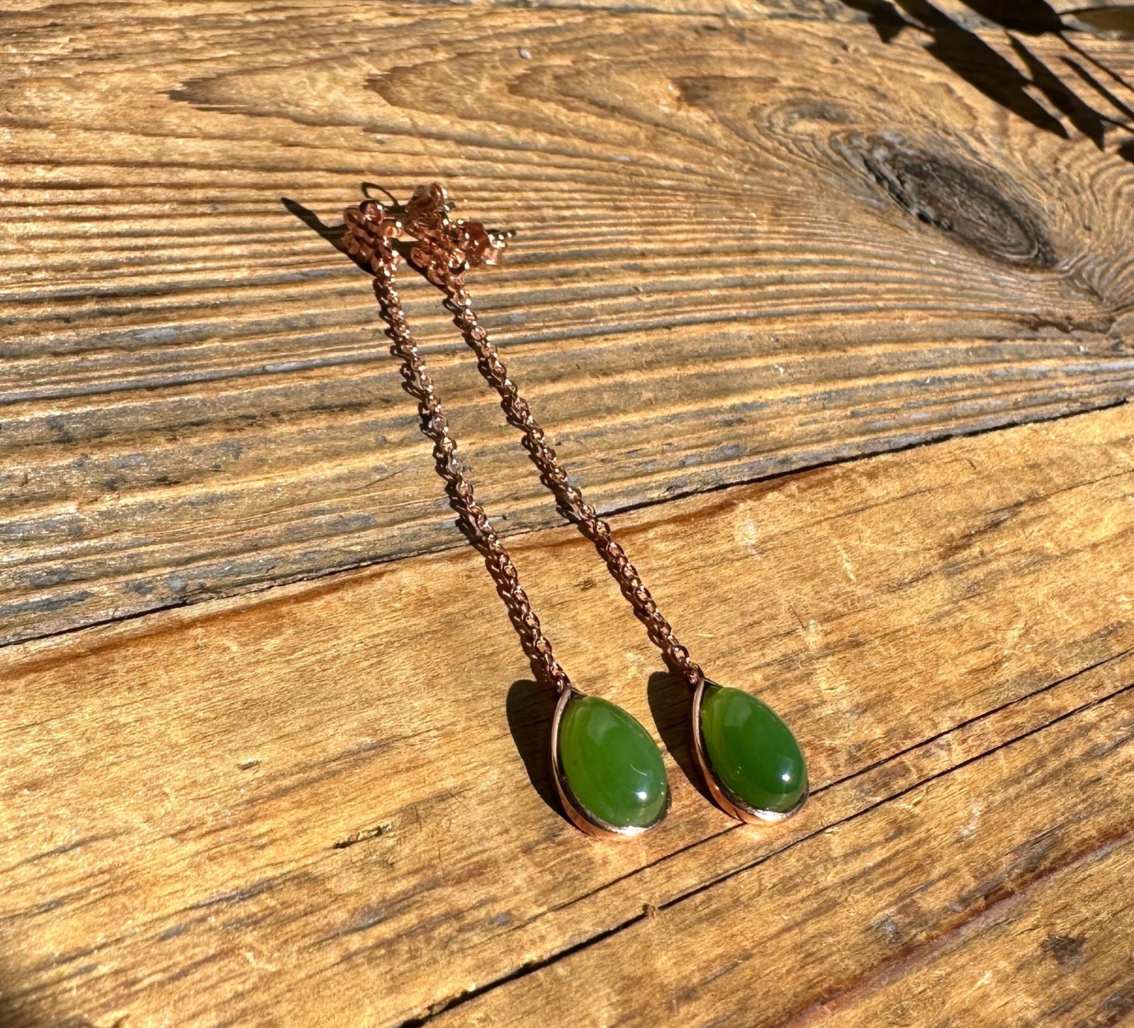 AA Jade Earrings #424 copper toned chain earrings with green jade drops and pink crystal cluster at the top on wood