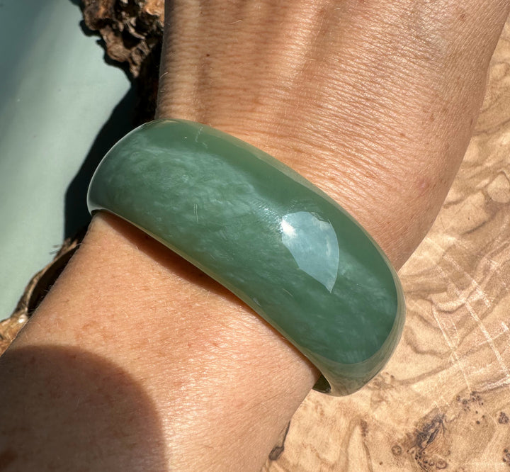 Wrist shot showing the pale green A Grade Siberian jade bangle worn on the arm.