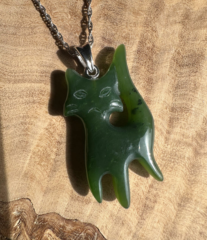 Grumpy Canadian Jade Cat Pendant on a silver chain, a green cat shaped pendant with a carved face
