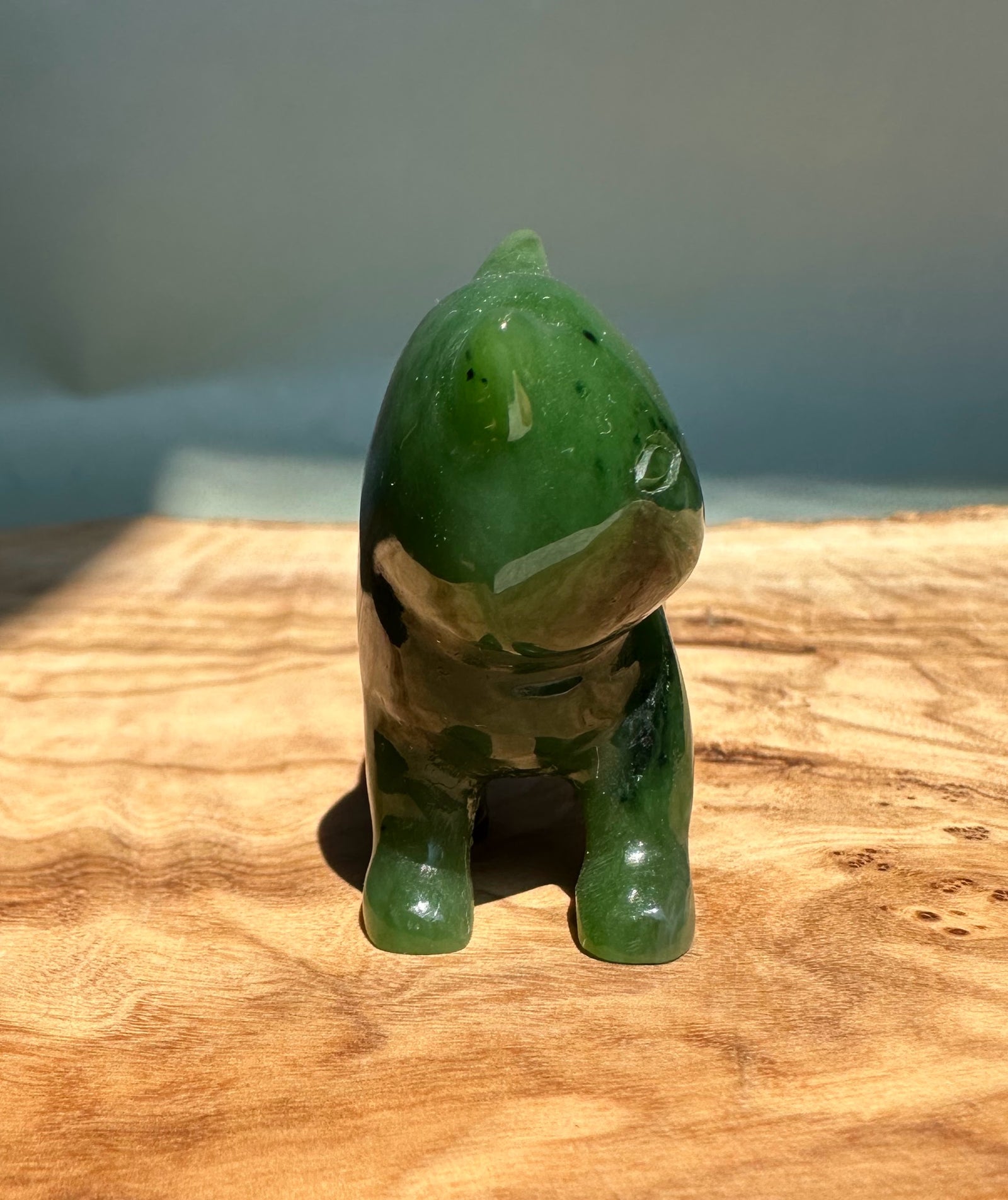 Canadian Jade cat figurine about 2 inches long viewed from the front in glossy green jade