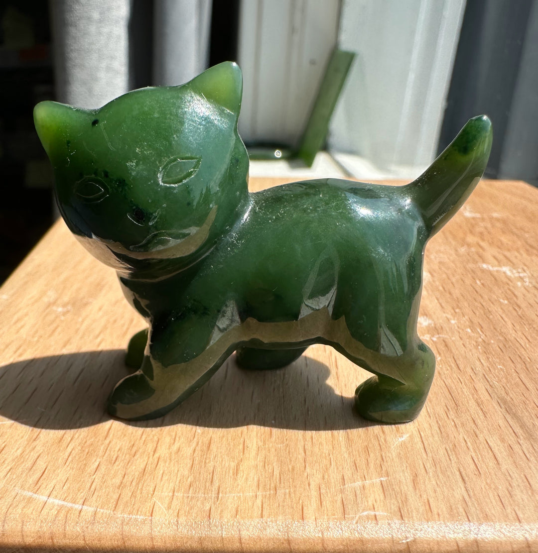 Three-quarter view of Canadian Jade cat figurine on a wooden surface.