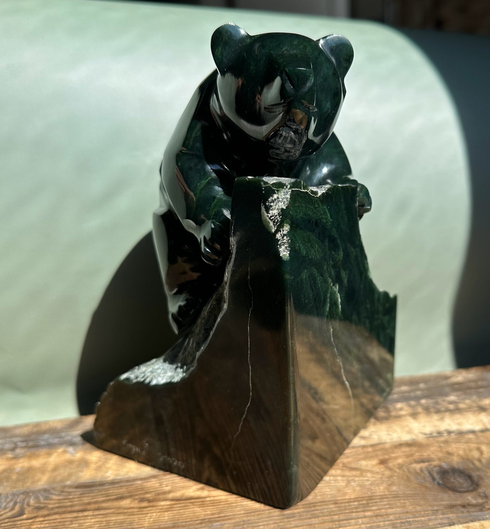 Dark Green Ogden Jade Bear by Lyle Sopel perched on a jagged stone base