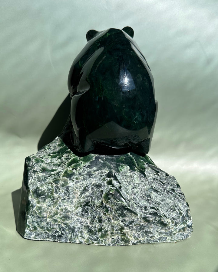 Back view of dark green Ogden jade bear sculpture by Lyle Sopel on a rough rock base