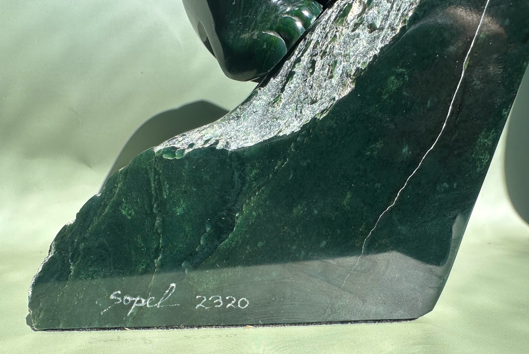 Base of a dark green Ogden jade bear by Lyle Sopel with textured carving and signature.