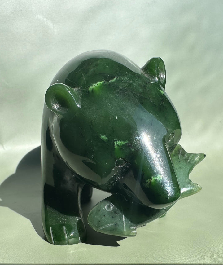 Profile view of a glossy green jade bear with rounded ears and a snout.