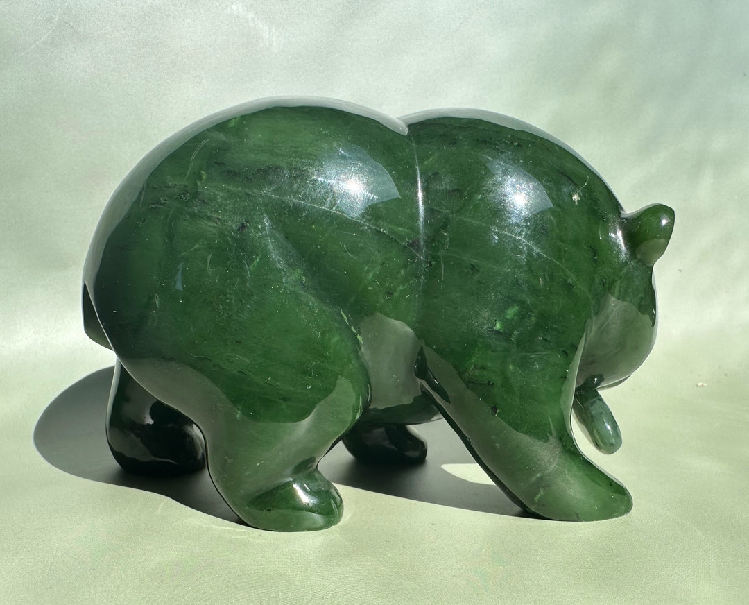Rear three-quarter view of the Canadian Jade Bear in rich green jade with smooth curves.