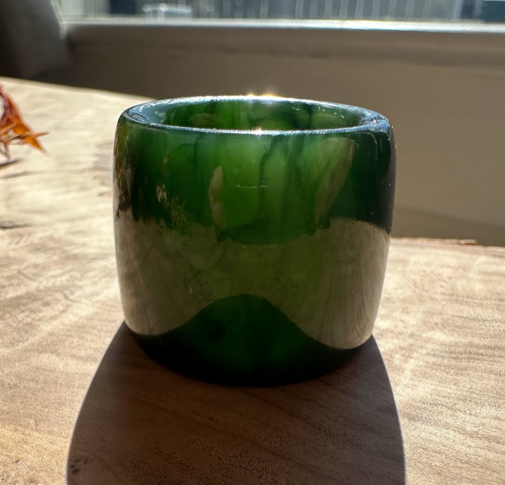 Canadian Ogden Jade Thumb Ring size 13 in deep green jade resting on a wooden surface by a window