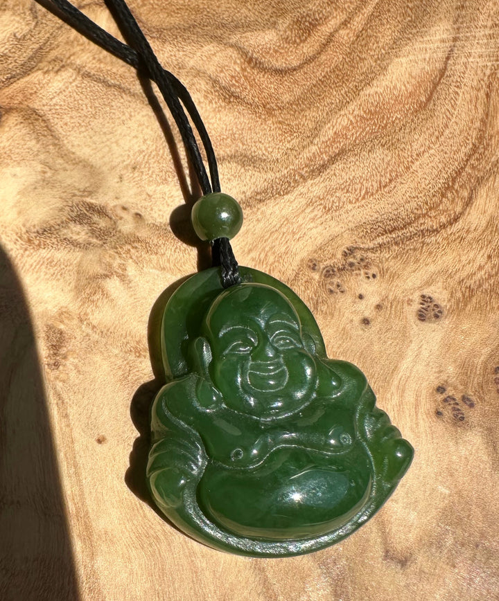 Green jade Laughing Buddha pendant on a black cord with a small green bead near the top
