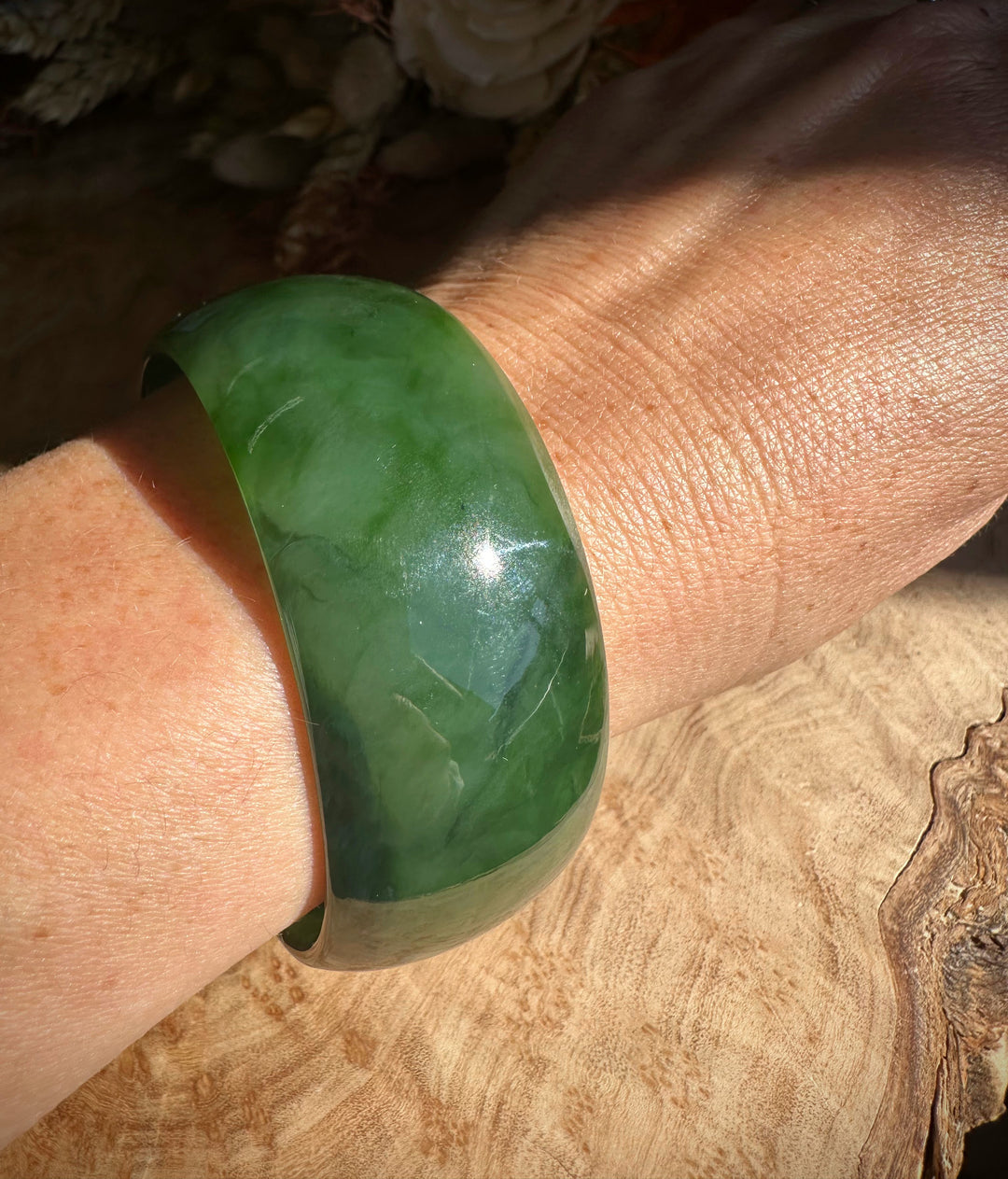 A Grade Ogden Jade Bangle worn on the wrist with a vivid green polished surface