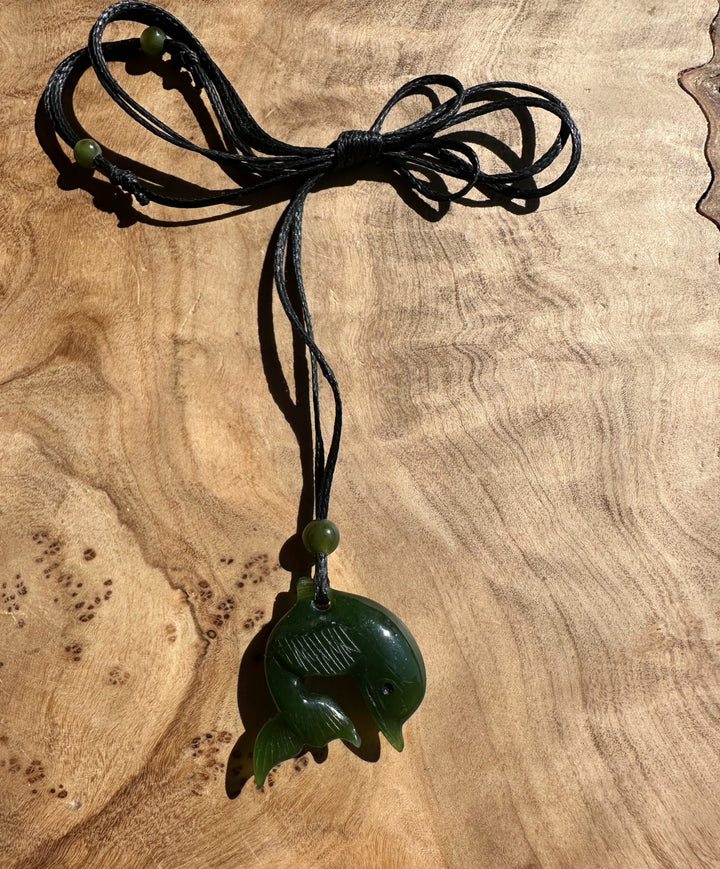 Multi strand black cord necklace featuring a green jade dolphin pendant and matching green beads