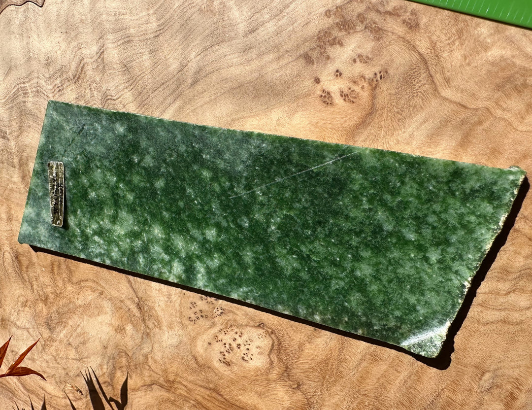 Wyoming Snowflake Jade slab long rectangular on wood surface.