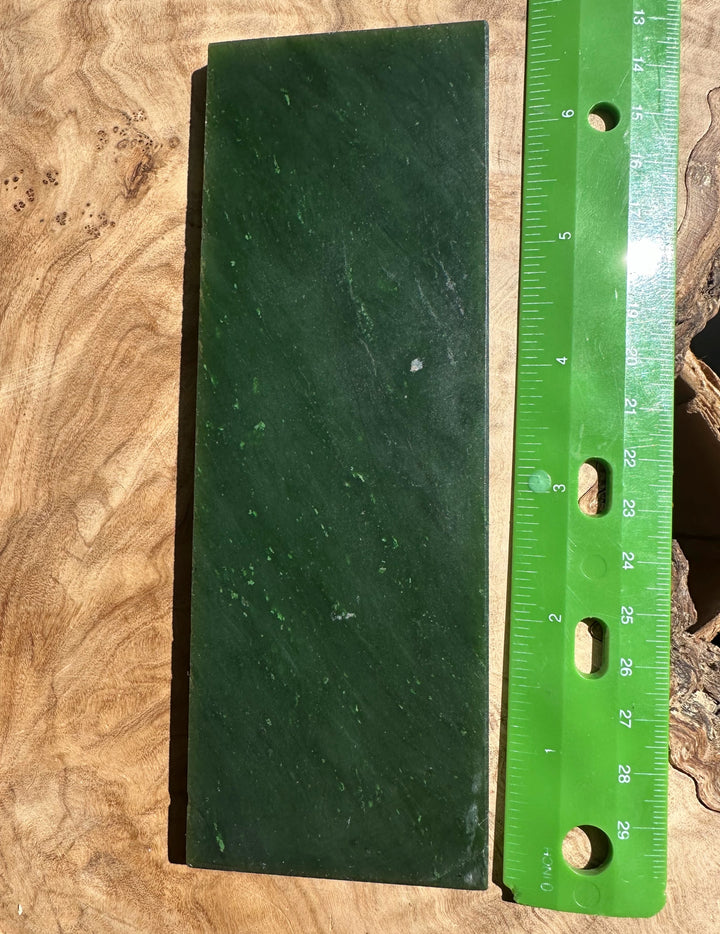 A Grade Canadian jade slab weighing 200 grams shown with a ruler for scale on a wooden surface.