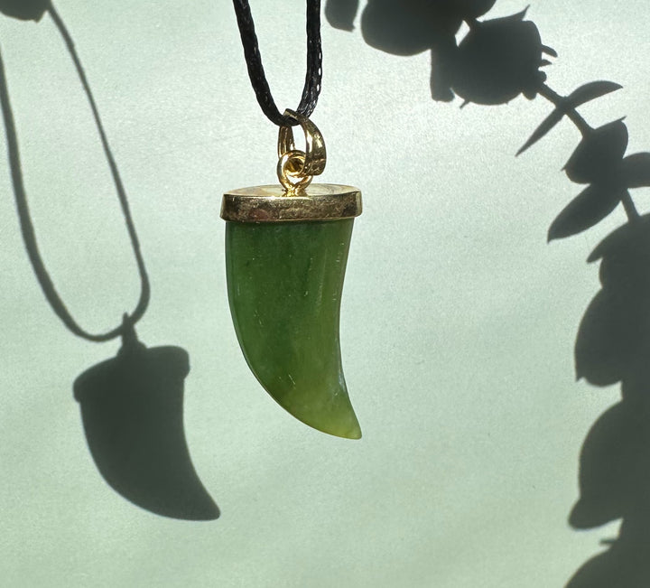 Green jade bear claw pendant with gold cap on a black cord