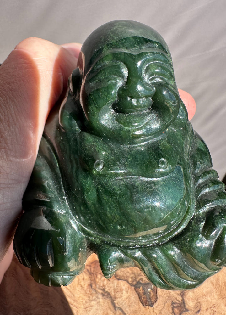 Close up of a 2.5 inch dark green jade Buddha with a smiling face