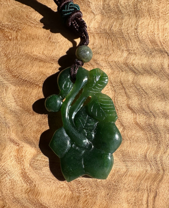 Green jade pendant on a wooden surface