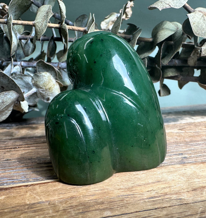 Rear angle of the green jade owl and owlet sculpture showing smooth curved surfaces.