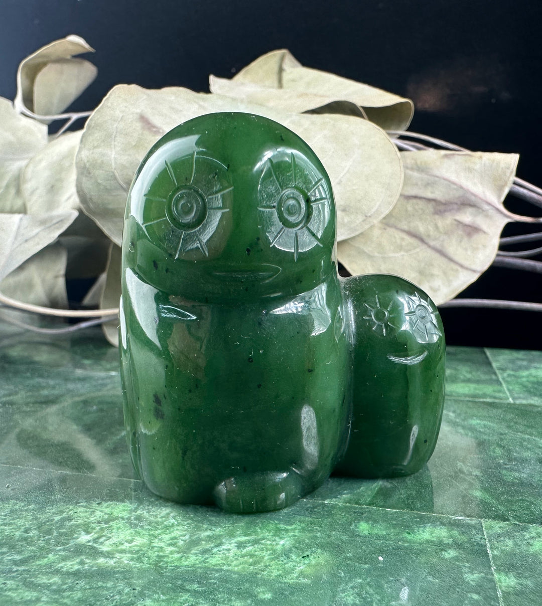 Pair of polished green jade owl figurines, a larger owl with a smaller owlet beside it.