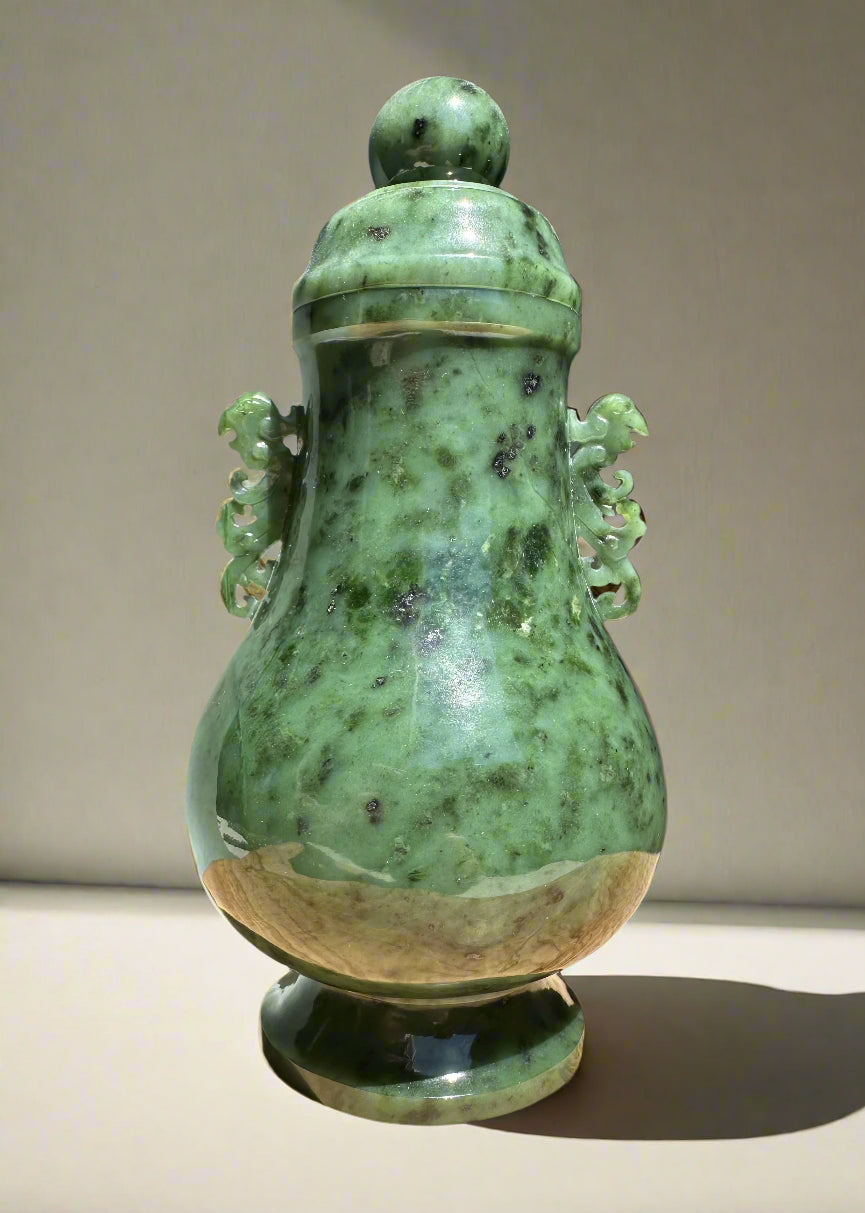 Green river jade vase with lid and curling decorative handles on both sides.