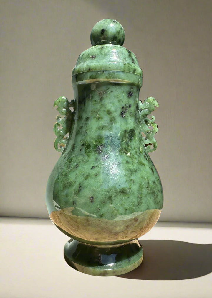 Green river jade vase with lid and curling decorative handles on both sides.