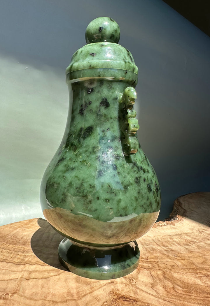 Canadian River Jade Vase with lid and round knob in green speckled jade on a wooden surface