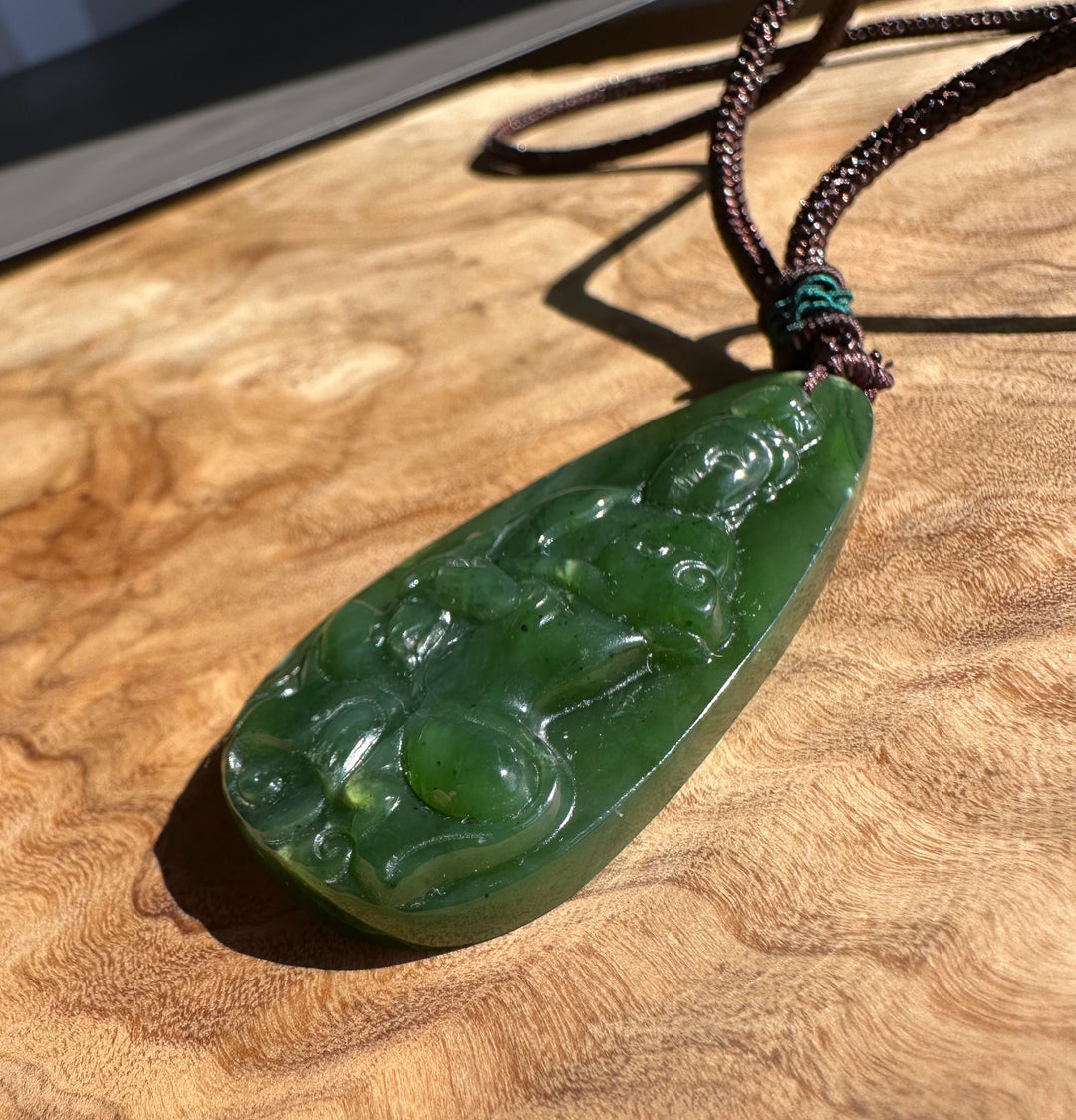 Green jade pendant on a wooden surface