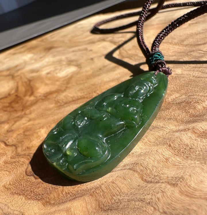 Green jade pendant on a wooden surface