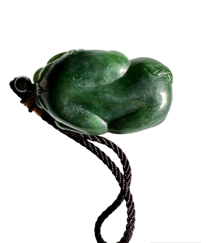 Green jade panda pocket pendant with brown braided cord on white background