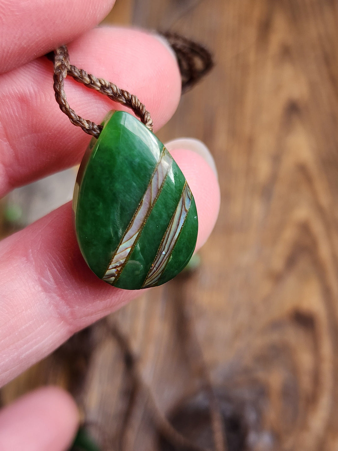 Canadian nephrite jade teardrop pendant with abalone inlay on a brown braided cord