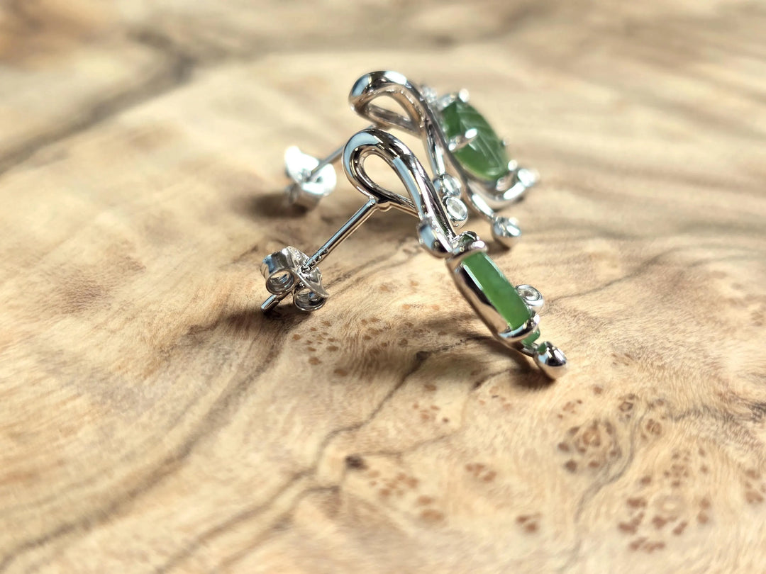 Side view of Canadian jade leaf and silver earrings showing a green jade leaf set in curling silver vines with crystal accents.