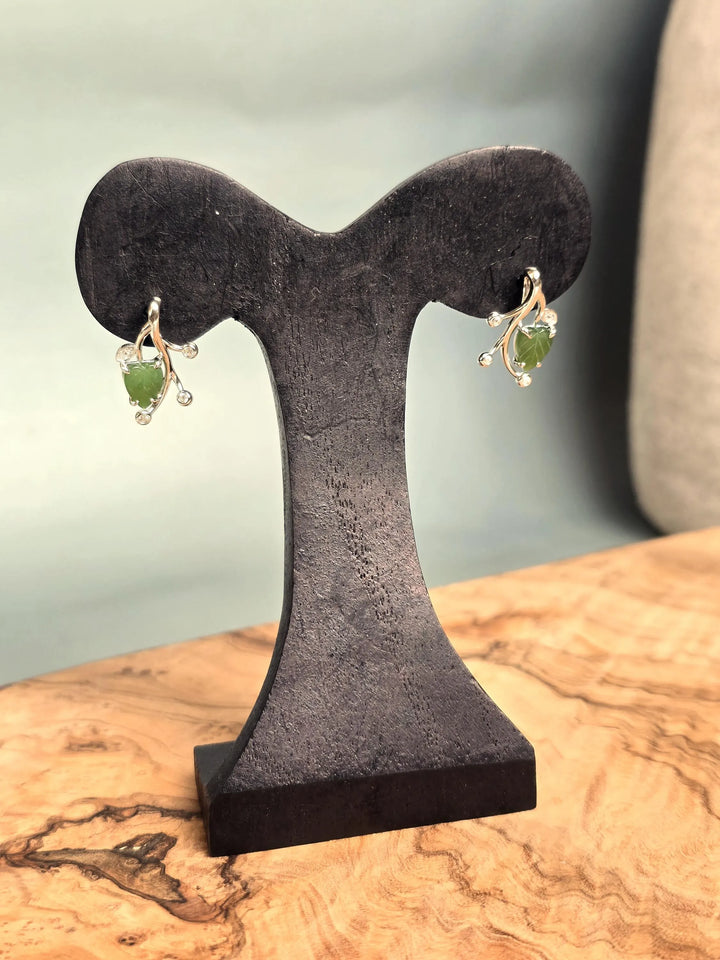Canadian Jade Leaf and Silver Earrings displayed on a black stand with the green jade leaves and silver vines