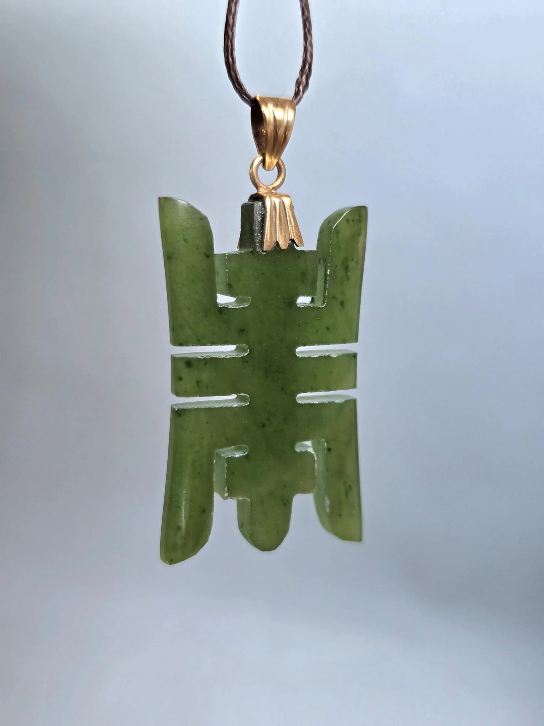 Vintage Chinese longevity pendant carved from nephrite jade with a 14k plated bail on a brown cord