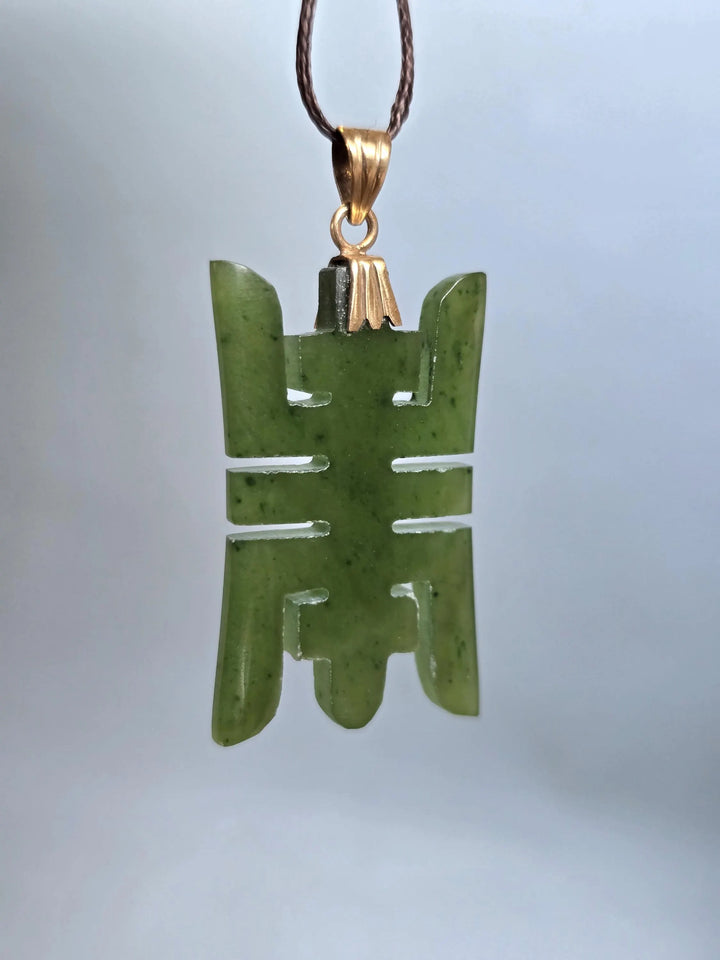 Vintage Chinese longevity pendant carved from nephrite jade with a 14k plated bail on a brown cord
