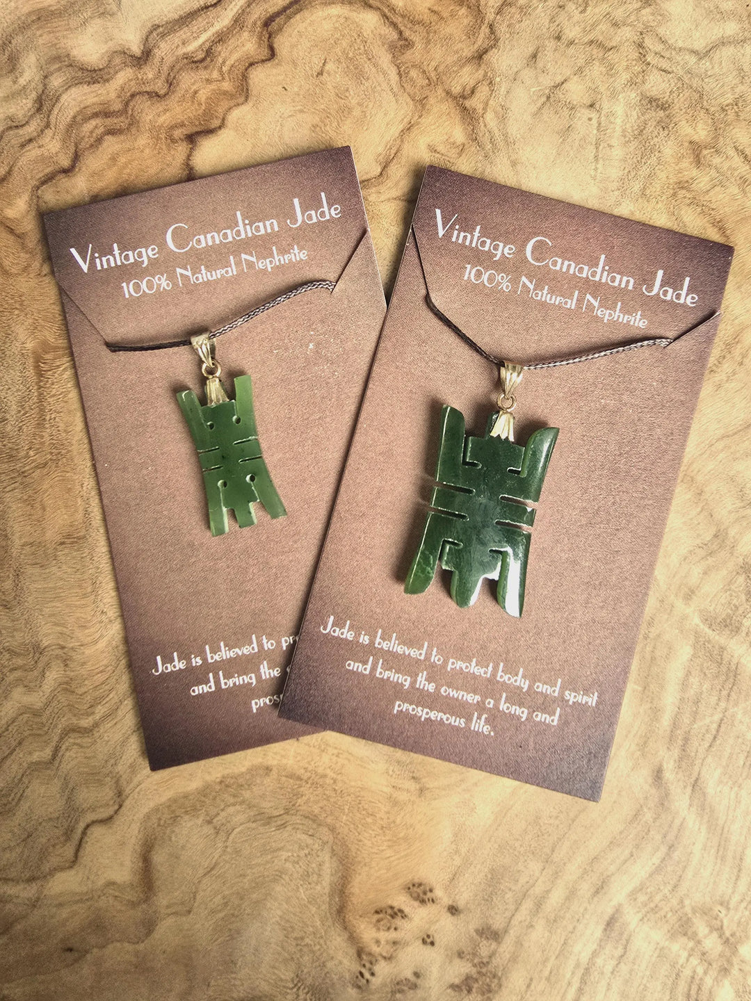 Pair of vintage Chinese longevity jade pendants with 14k plated bails on brown display cards