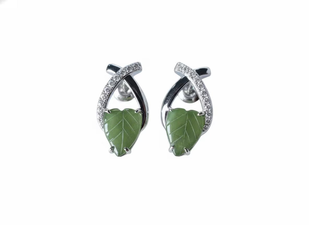 Pair of earrings with green leaf-like jade on a white background