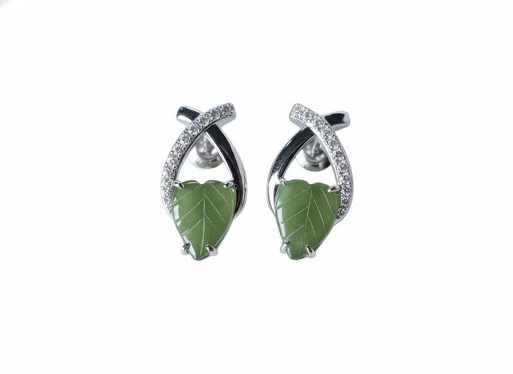 Pair of earrings with green leaf-like jade on a white background