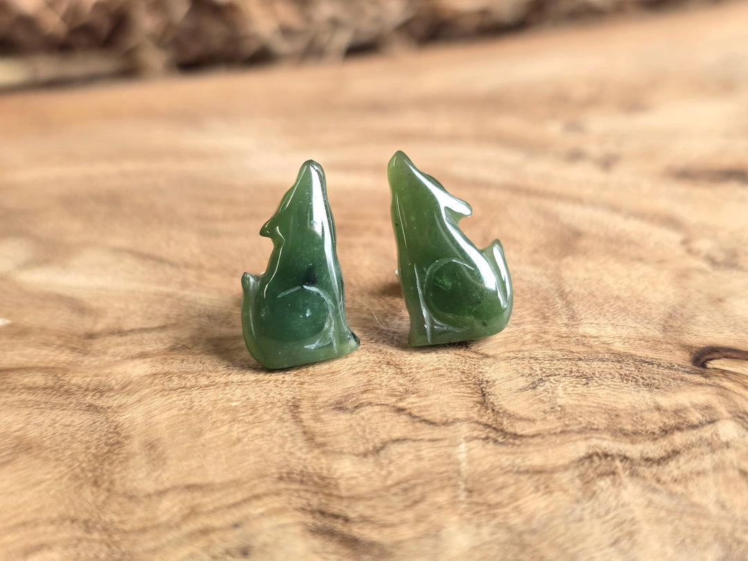 Green jade earrings on a wooden surface