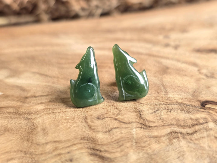 Green jade earrings on a wooden surface