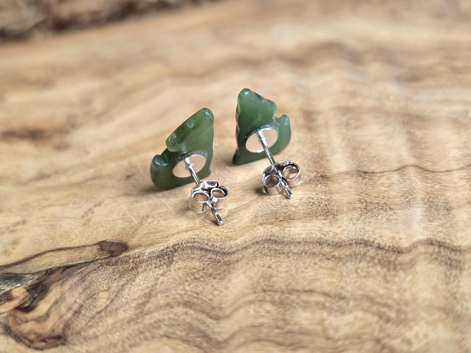 Green stone earrings on a wooden surface