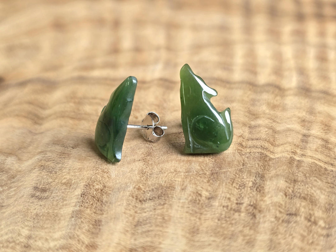 Green jade earrings on a wooden surface