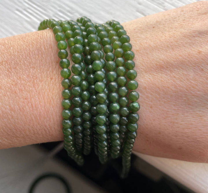 Close up of 4mm nephrite jade bead strands wrapped around a wrist