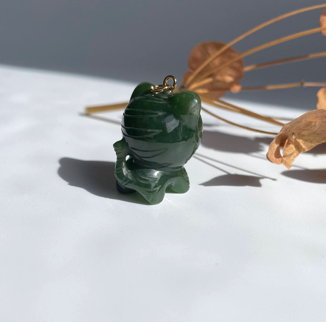 Dark green jade tiger charm with a gold loop on top, carved in a cute cartoon style