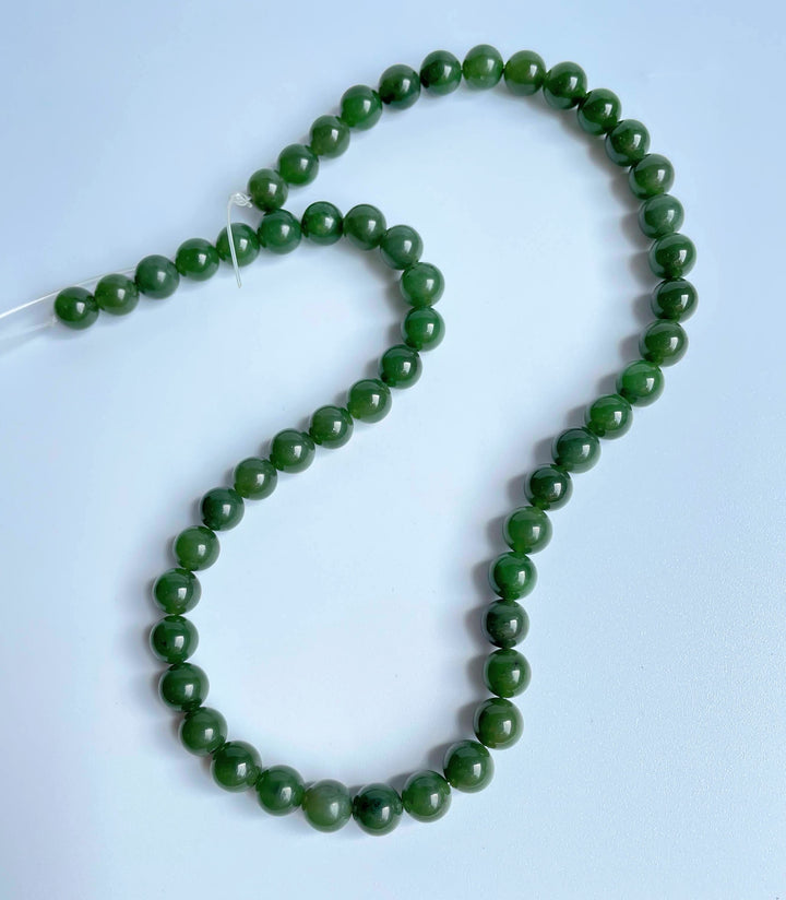8mm carving grade Canadian jade beads on a loose strand.