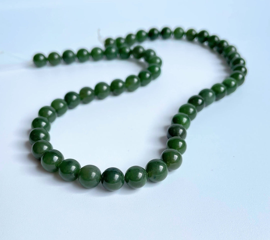 8mm carving grade Canadian jade beads arranged in a curved strand