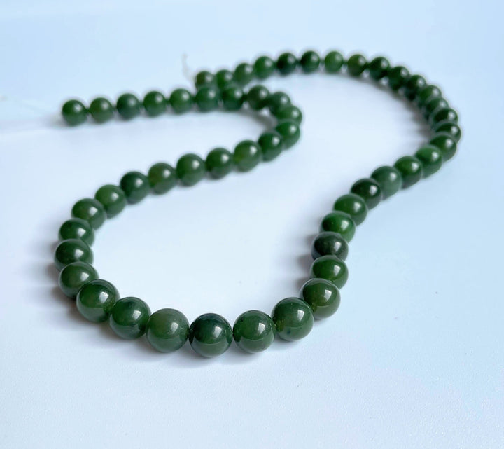 8mm carving grade Canadian jade beads arranged in a curved strand