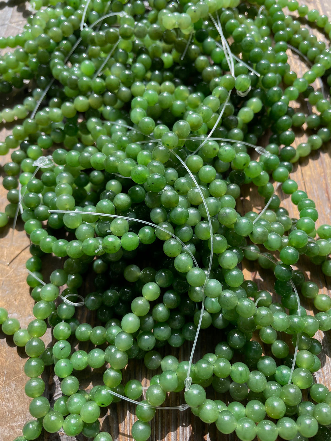 Close-up of green 6mm beads on clear thread