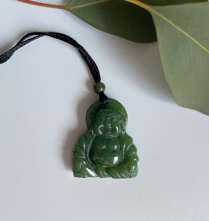 Happy Buddha pendant carved from green jade on a black braided cord with a small bead above